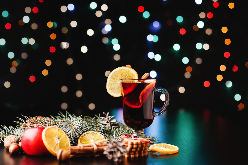 Festive mulled wine with holiday decorations and a backdrop of twinkling multicolored lights
