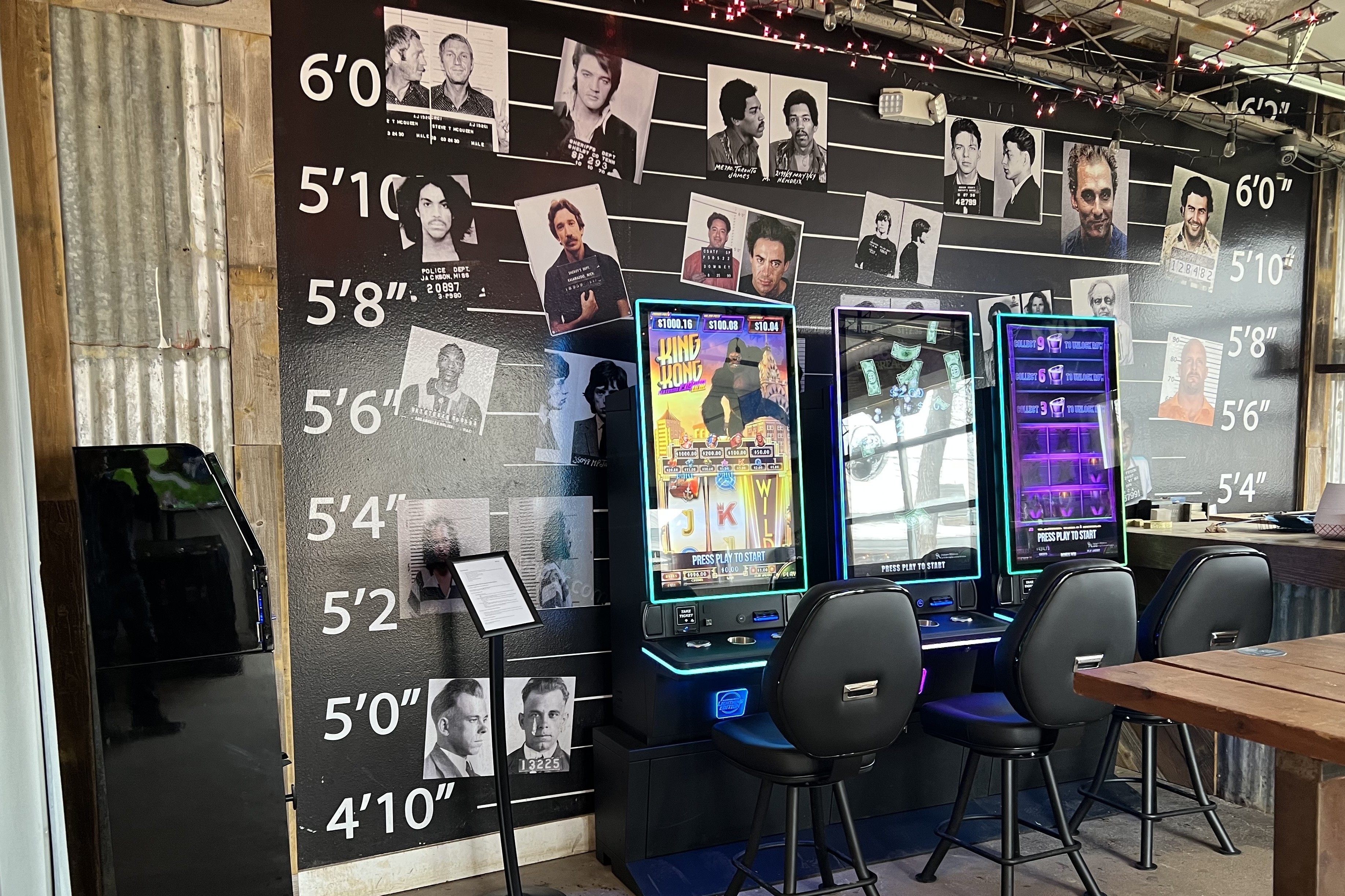 Three modern Texas skill game machines set up against a unique, themed wall in a bar, ready for patron entertainment.