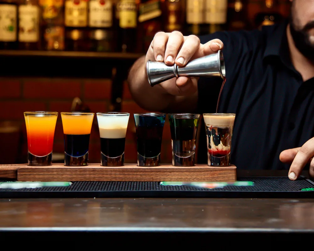 Expert drink service at a well-lit bar, showing how a positive guest experience is shaped by a bar's aesthetic and professional atmosphere.