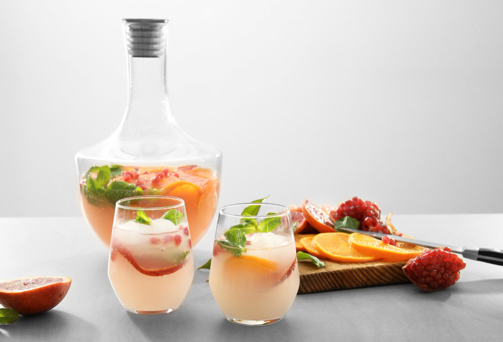 Refreshing Texas pomegranate and citrus shrub tonic in stemless glasses with fresh mint and ice.